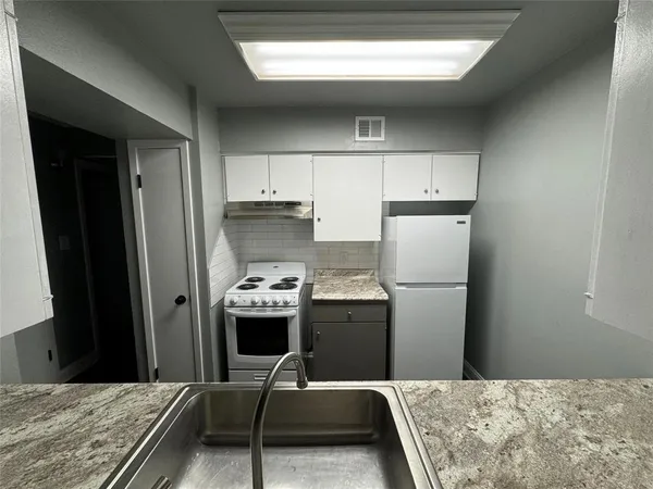 a room with a bed and a refrigerator
