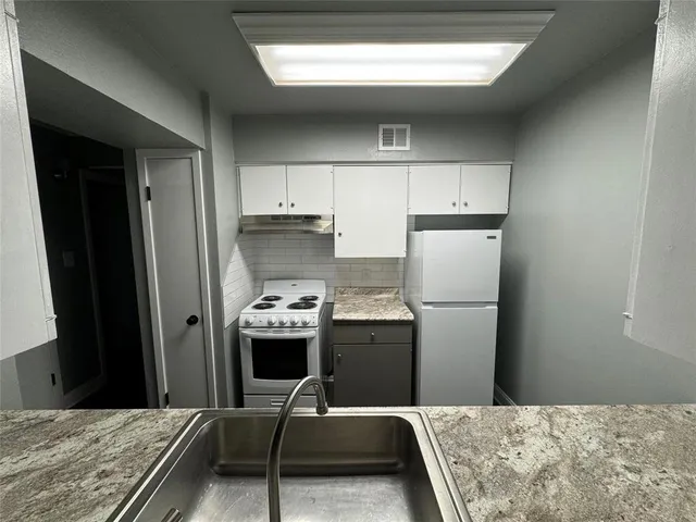 a room with a bed and a refrigerator