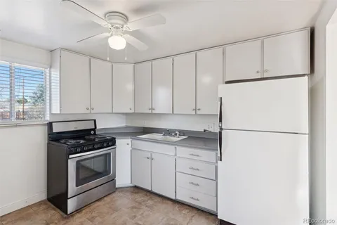 a kitchen with white cabinets and white appliances