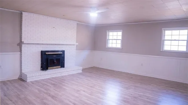 an empty room with wooden floor and fireplace