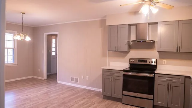 a kitchen with a stove and a wooden floor