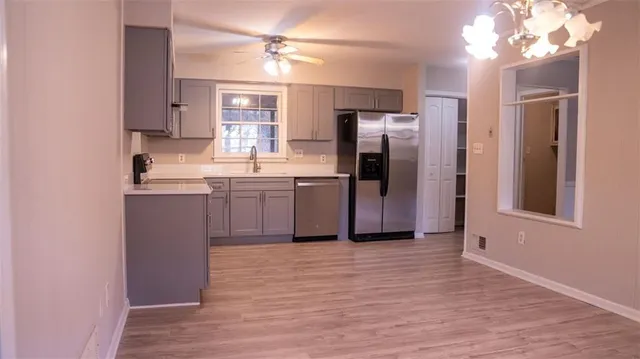 a kitchen with stainless steel appliances granite countertop a refrigerator a sink a stove and oven