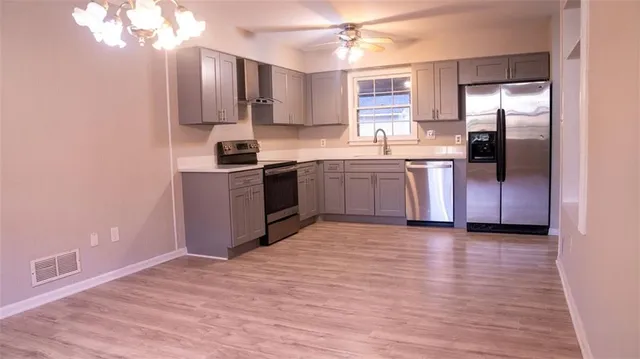 a kitchen with stainless steel appliances granite countertop a refrigerator stove top oven and sink