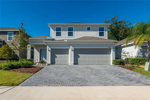 a front view of a house with yard and trees