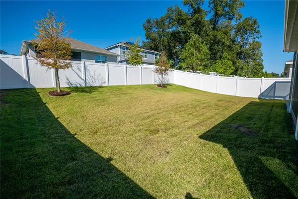 a view of a backyard with wooden fence