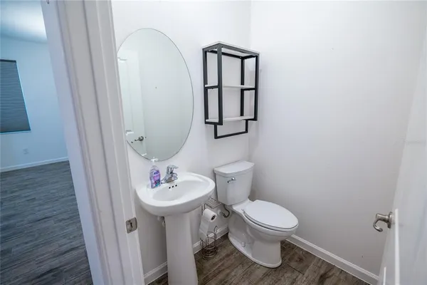 a kitchen with stainless steel appliances a sink a stove a refrigerator a center island and wooden floor