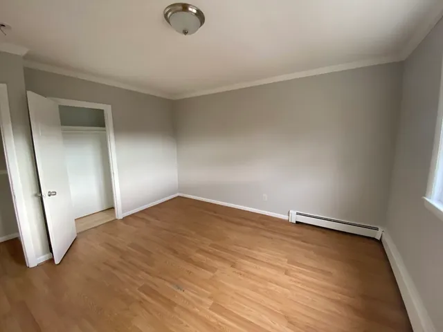 a view of empty room with wooden floor