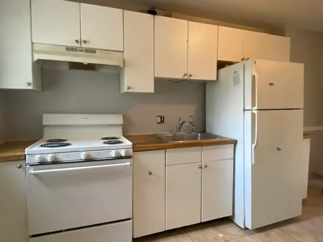 a kitchen with appliances a sink and cabinets