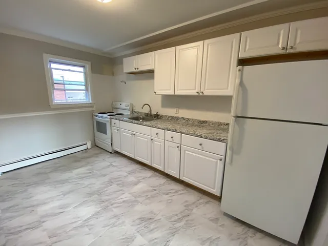 a kitchen with white cabinets and white appliances
