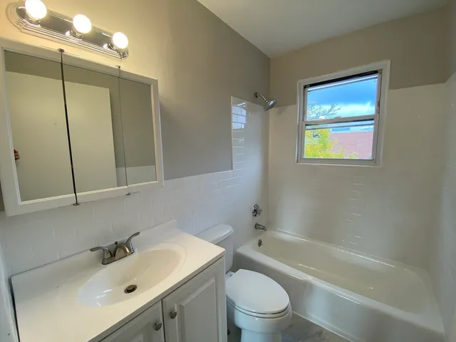 a bathroom with a sink mirror toilet and bathtub