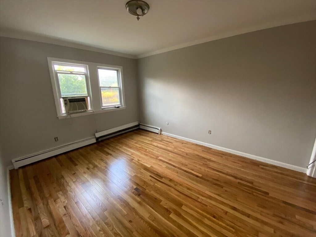 157-167 Delhi Street Boston, MA 02126 - Photo 10 of 16 an empty room with wooden floor and windows