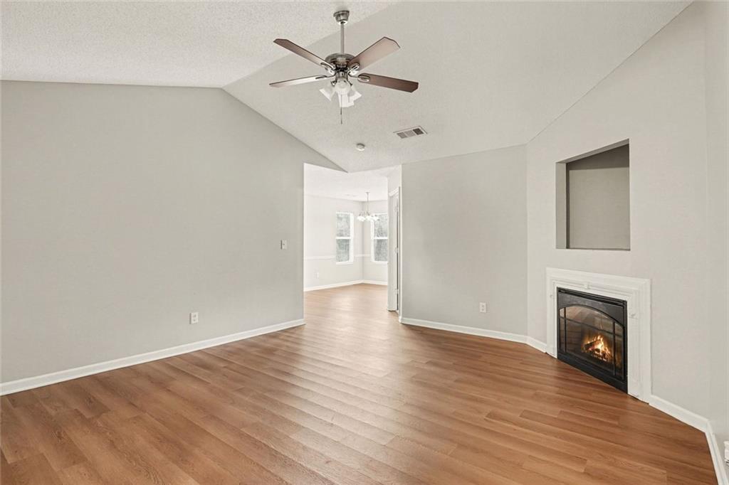 85 Homestead Place Rex, GA 30273 - Photo 3 of 17 wooden floor in an empty room with a fireplace