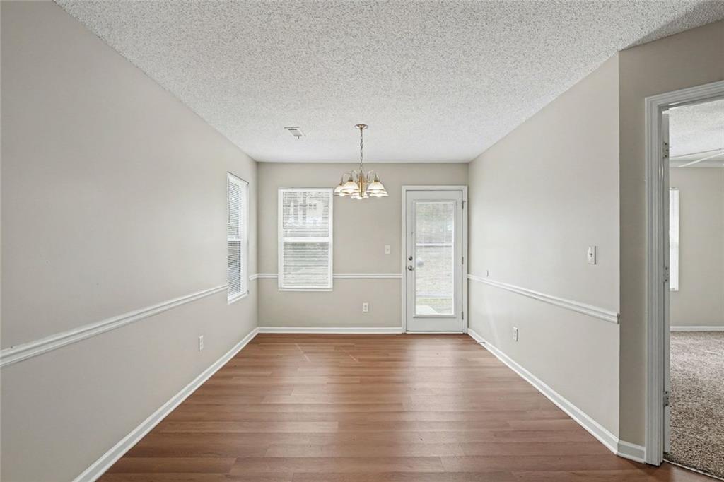 85 Homestead Place Rex, GA 30273 - Photo 5 of 17 wooden floor in an empty room with a window