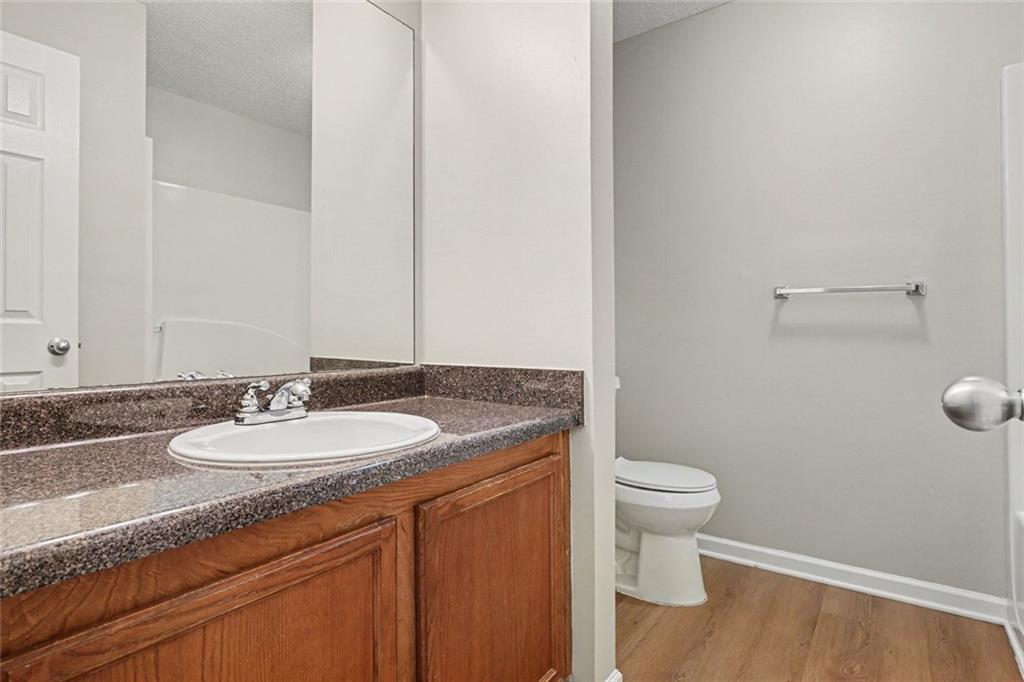 85 Homestead Place Rex, GA 30273 - Photo 9 of 17 a bathroom with a granite countertop sink a toilet and a mirror
