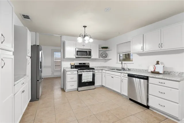a kitchen with white cabinets and entryway