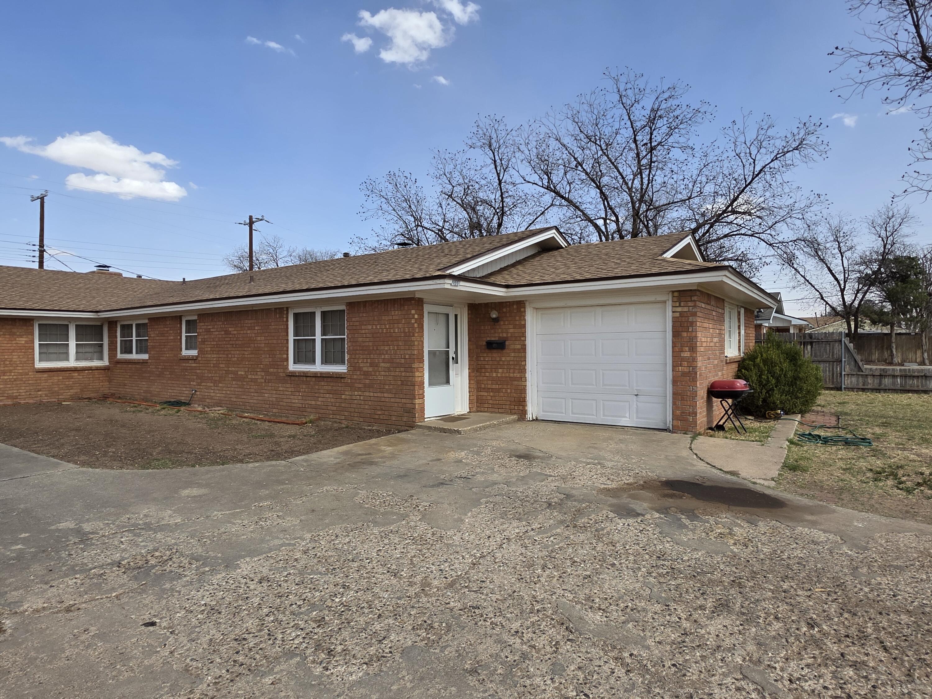 2008 54th Street Lubbock, TX 79412 - Photo 2 of 14 a view of a house with a yard and garage