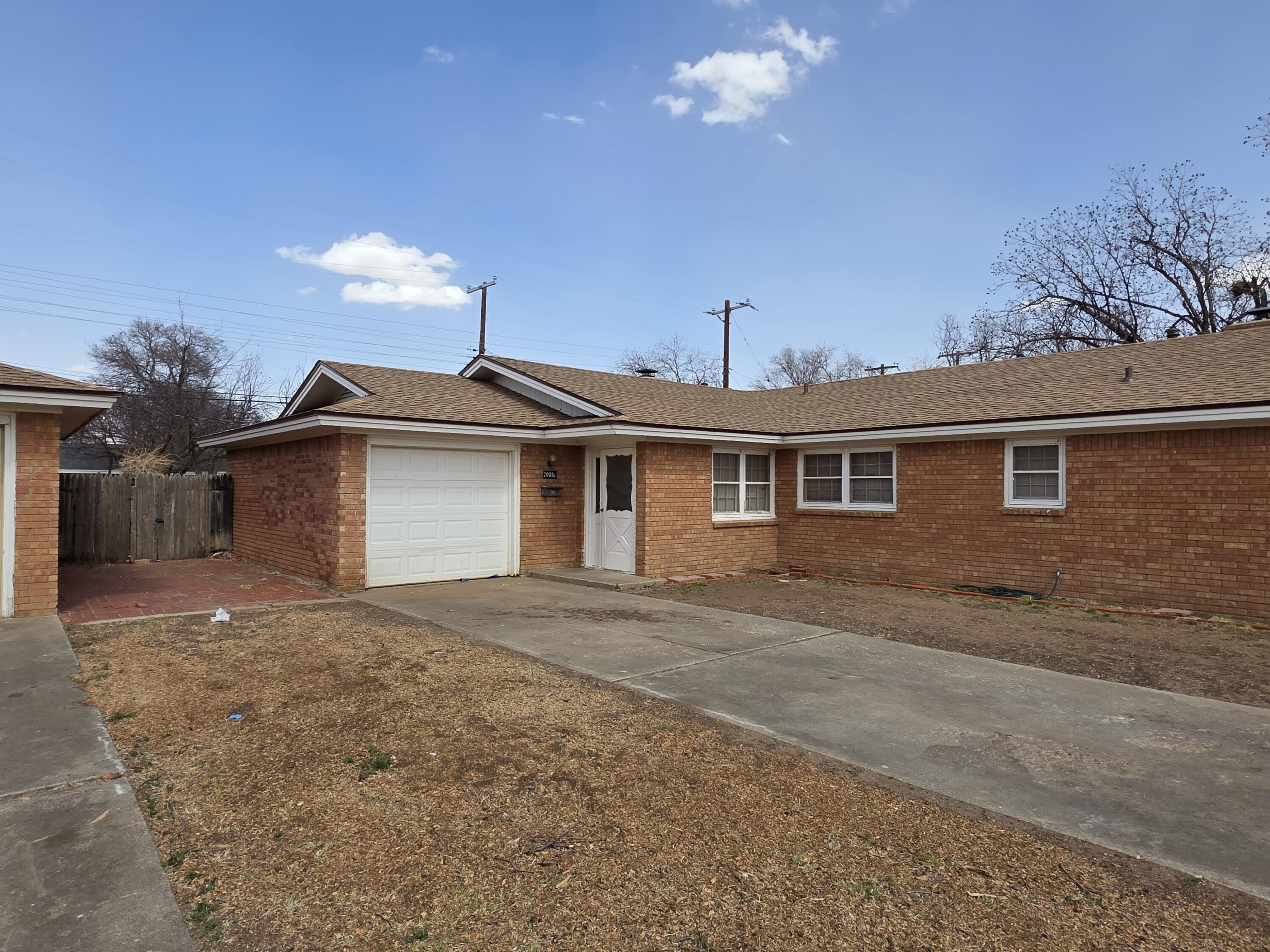 2008 54th Street Lubbock, TX 79412 - Photo 3 of 14 a view of a house with a yard and garage
