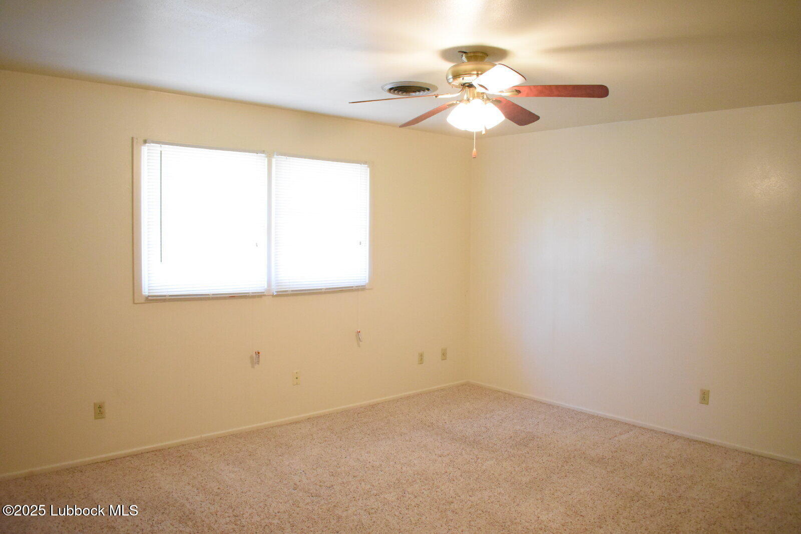 2008 54th Street Lubbock, TX 79412 - Photo 10 of 14 an empty room with a window and a chandelier fan