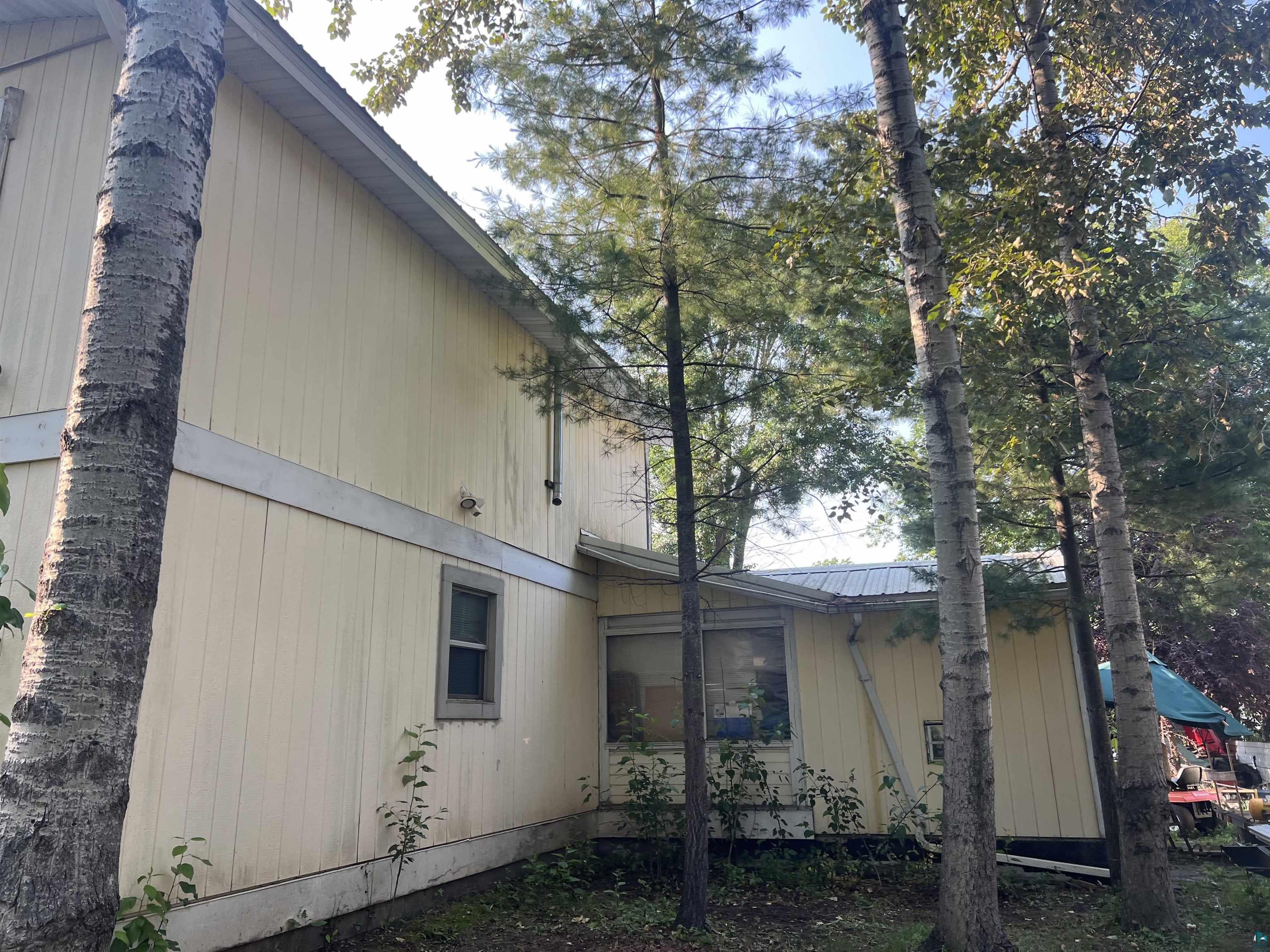 107 6th Street South Virginia, MN 55792 - Photo 3 of 7 Two-story property featuring light-colored vertical siding and a visible window with dark trim