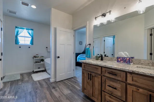 a en suite bathroom with a granite countertop sink and a mirror