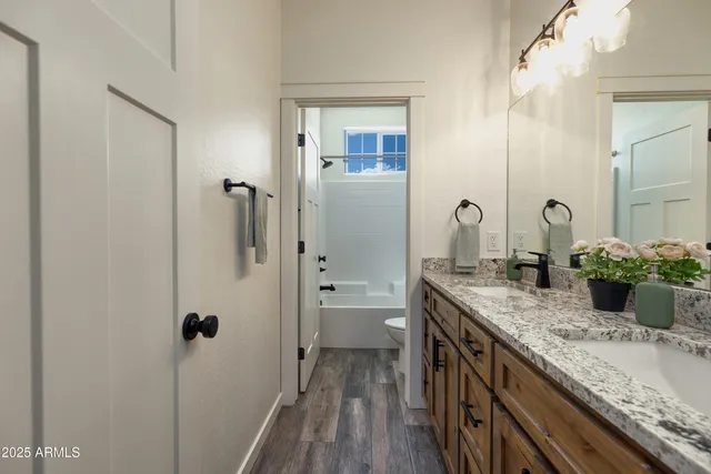 a bathroom with a granite countertop sink a toilet and shower