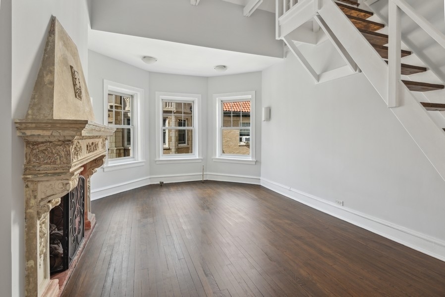 534 West Brompton Avenue, Unit 3N Chicago, IL 60657 - Photo 4 of 19 a view of an empty room with wooden floor and a fireplace