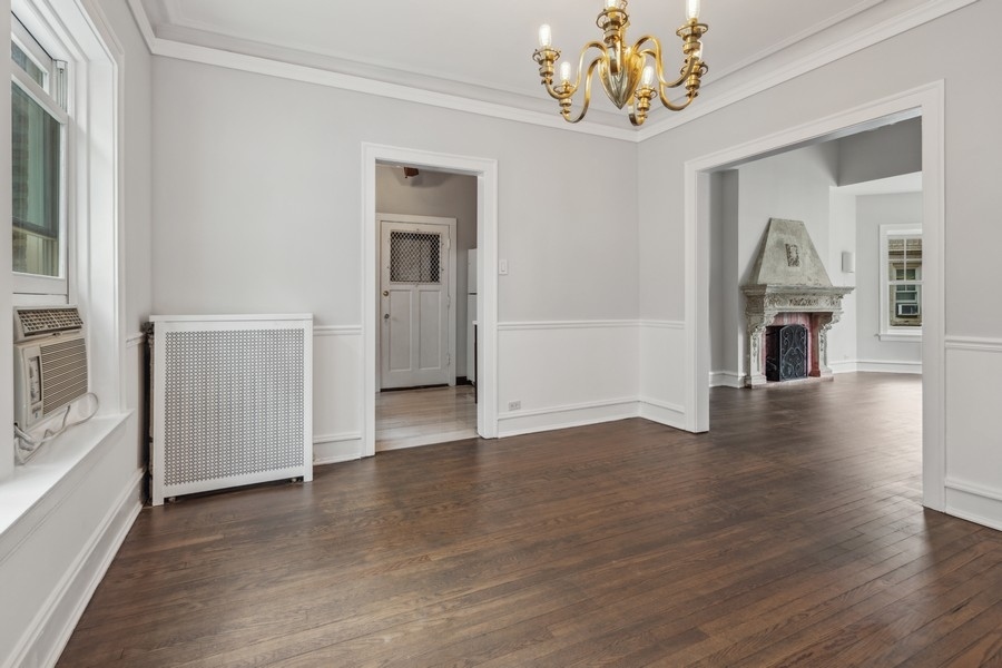 534 West Brompton Avenue, Unit 3N Chicago, IL 60657 - Photo 8 of 19 an empty room with wooden floor chandelier and windows