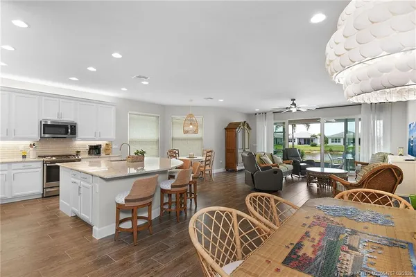 a kitchen with stainless steel appliances granite countertop a stove a sink a dining table and chairs