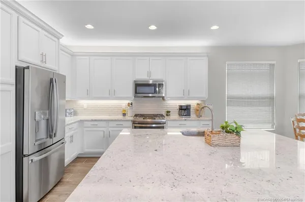a living room with furniture and a view of kitchen