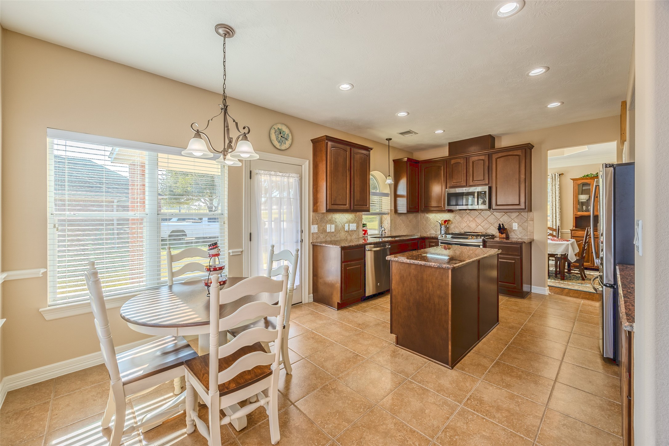 1905 Rosenbaum Drive Brenham, TX 77833 - Photo 15 of 30 a kitchen with a table chairs refrigerator and microwave