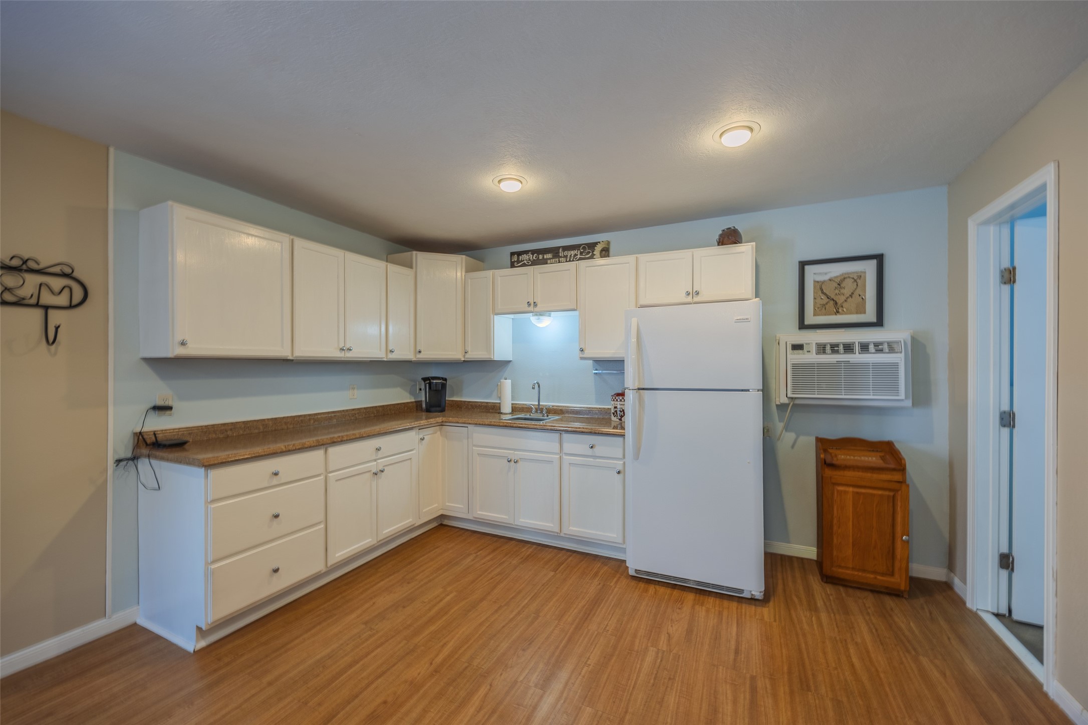 1905 Rosenbaum Drive Brenham, TX 77833 - Photo 30 of 30 a kitchen with wooden floors and white appliances
