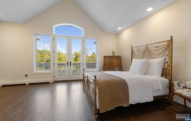 a spacious bedroom with a bed and wooden floor
