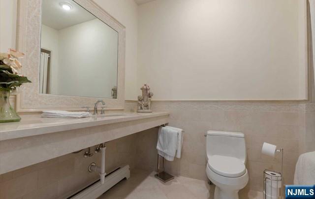 51 Chestnut Ridge Road Saddle River, NJ 07458 - Photo 28 of 45 a bathroom with a granite countertop toilet sink and mirror
