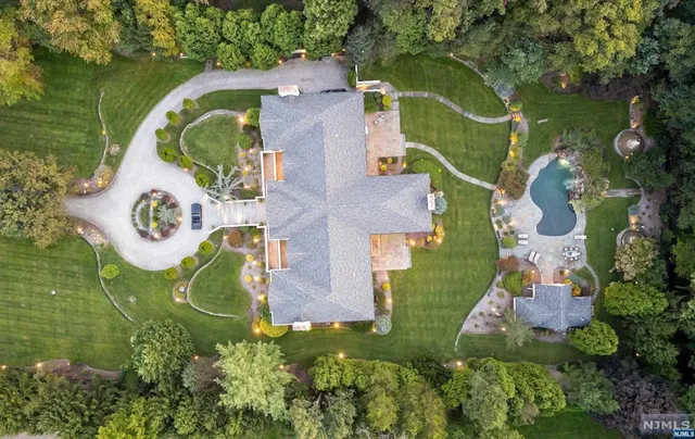 an aerial view of a house with a swimming pool and outdoor seating