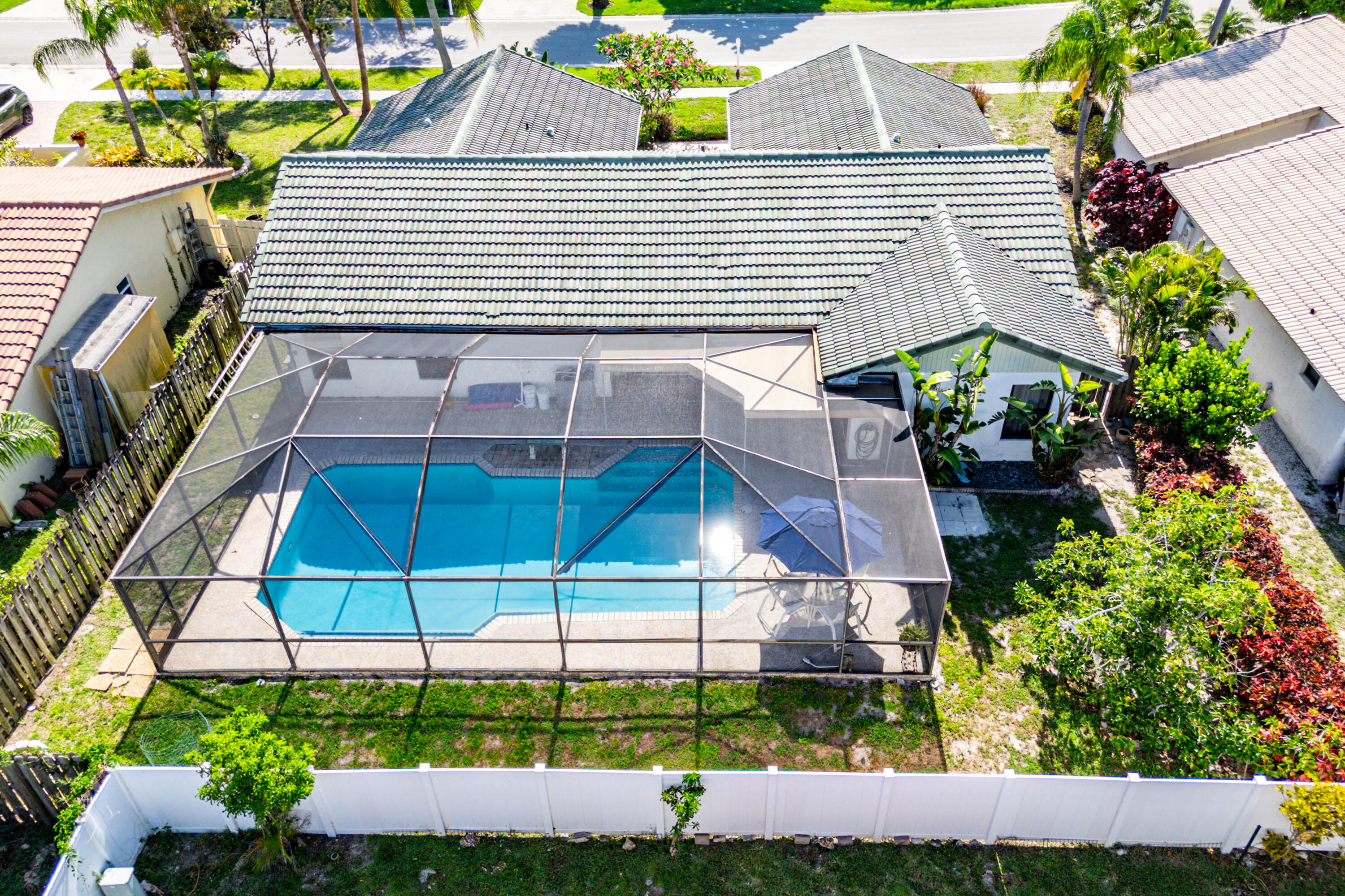 21212 Escondido Way Boca Raton, FL 33433 - Photo 33 of 48 a view of a small house with a yard and potted plants