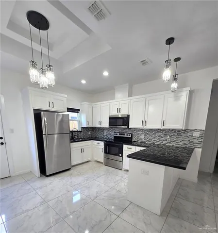 a kitchen with stainless steel appliances granite countertop a sink a stove a refrigerator cabinets and chairs
