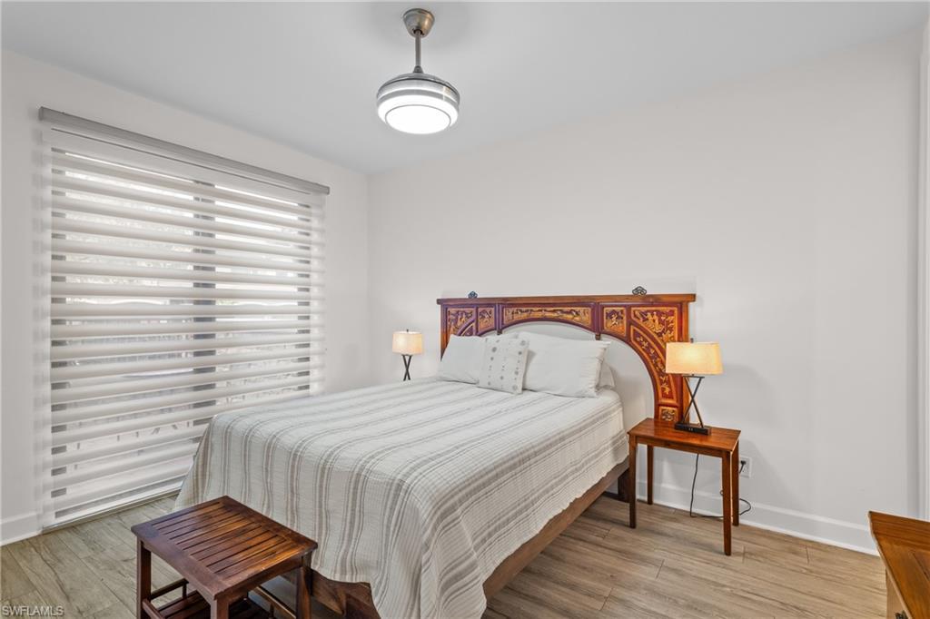 9637 Montelanico Loop, Unit 104 Naples, FL 34119 - Photo 17 of 45 Bedroom featuring light wood finished floors and baseboards