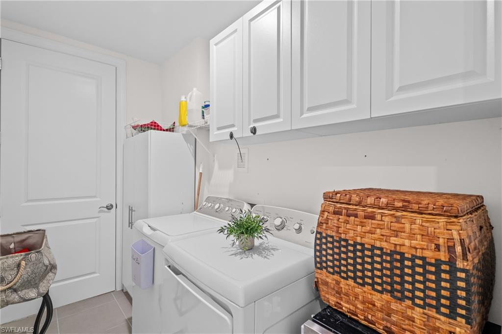 9637 Montelanico Loop, Unit 104 Naples, FL 34119 - Photo 20 of 45 Washroom featuring light tile patterned floors, washer and dryer, and cabinet space