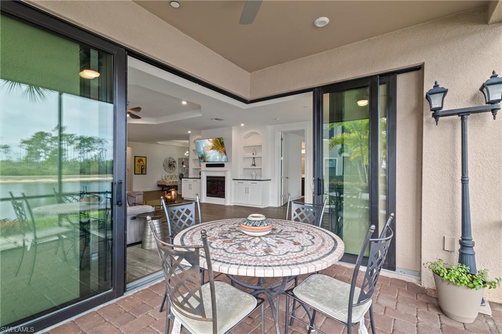9637 Montelanico Loop, Unit 104 Naples, FL 34119 - Photo 21 of 45 View of patio / terrace featuring ceiling fan, a water view, and outdoor dining space