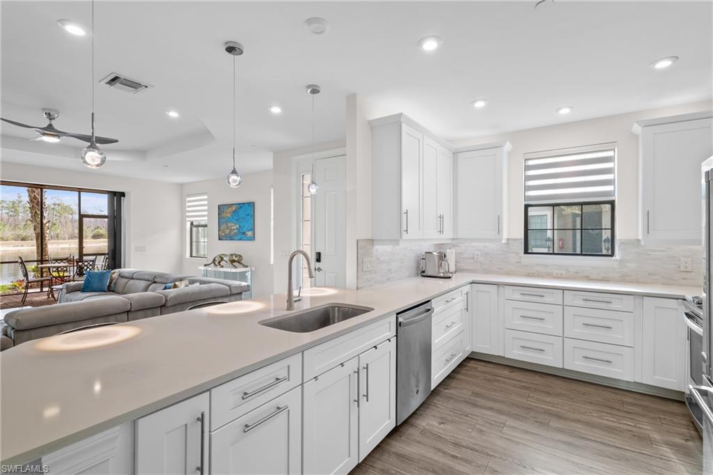 9637 Montelanico Loop, Unit 104 Naples, FL 34119 - Photo 43 of 45 Kitchen featuring decorative light fixtures, open floor plan, white cabinets, recessed lighting, and light stone countertops