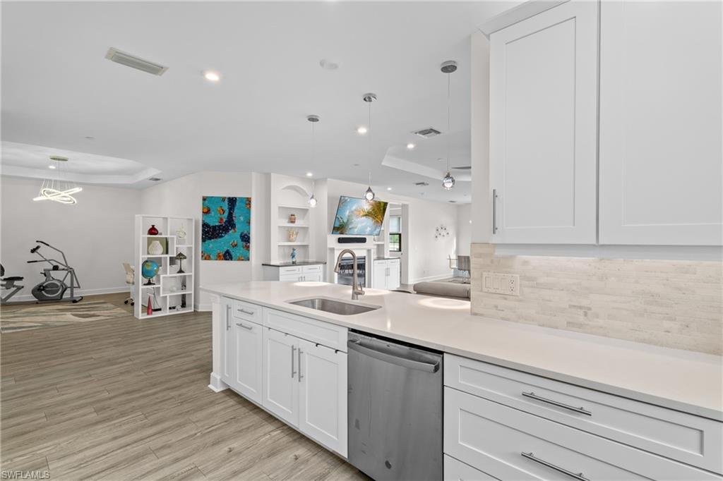 9637 Montelanico Loop, Unit 104 Naples, FL 34119 - Photo 44 of 45 Kitchen featuring a tray ceiling, open floor plan, white cabinets, dishwasher, and recessed lighting