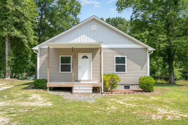 a view of a house with a yard chairs and potted plants