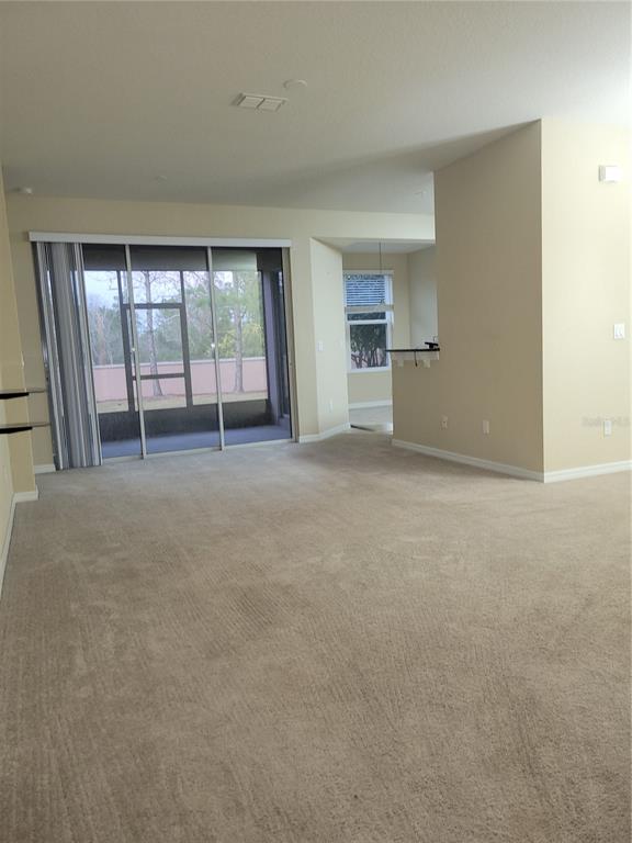 8335 Bella Vida Circle, Unit 8335 Davenport, FL 33896 - Photo 4 of 16 an empty room with a fireplace and windows