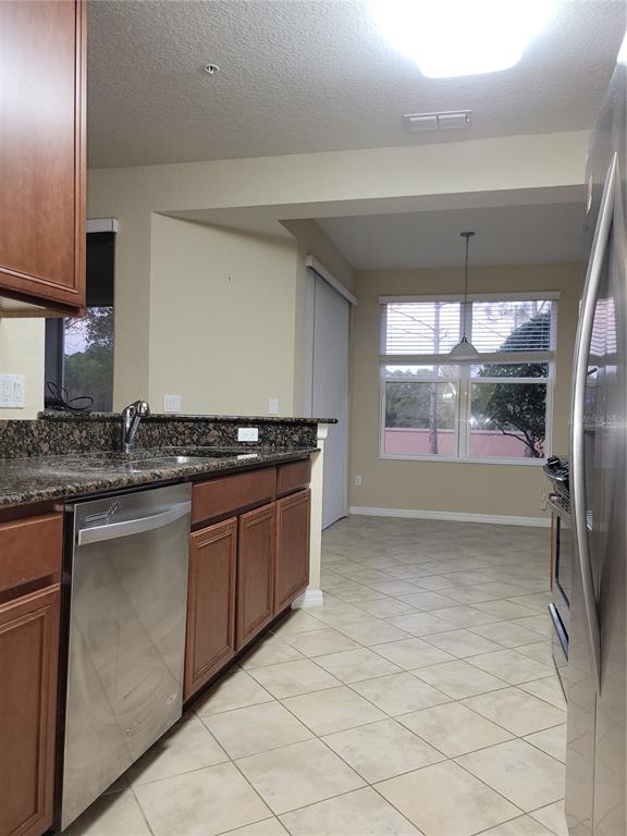 8335 Bella Vida Circle, Unit 8335 Davenport, FL 33896 - Photo 6 of 16 a kitchen with stainless steel appliances granite countertop a sink and a stove