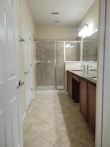 a bathroom with a granite countertop sink a large mirror and shower