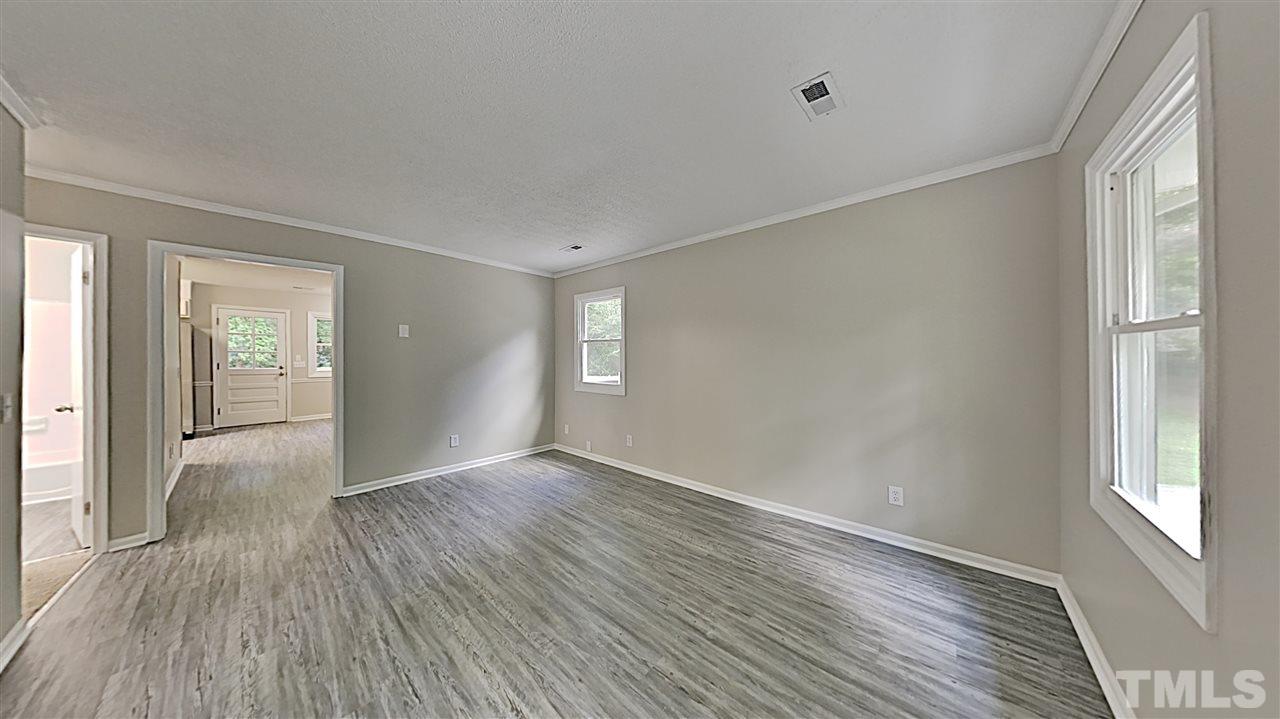 7209 Stuart Drive Raleigh, NC 27615 - Photo 2 of 13 a view of an empty room with window and wooden floor