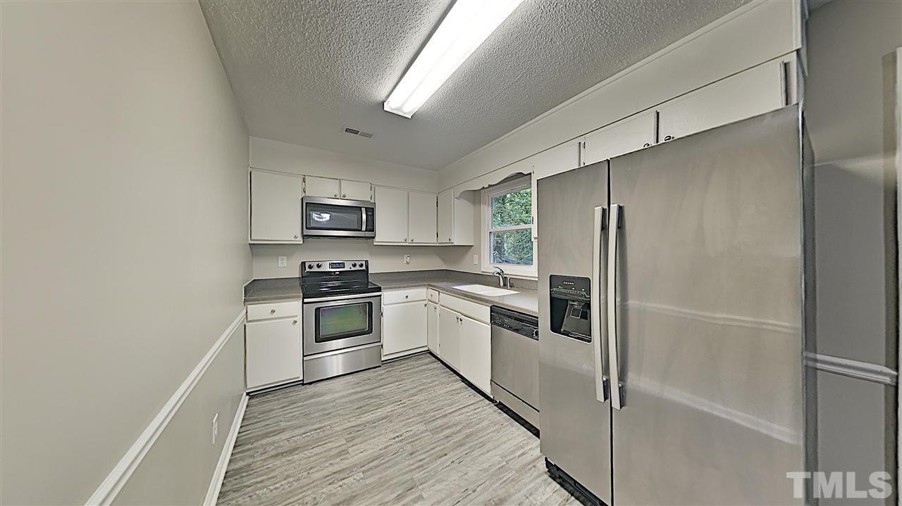 7209 Stuart Drive Raleigh, NC 27615 - Photo 4 of 13 a kitchen with cabinets stainless steel appliances and a window