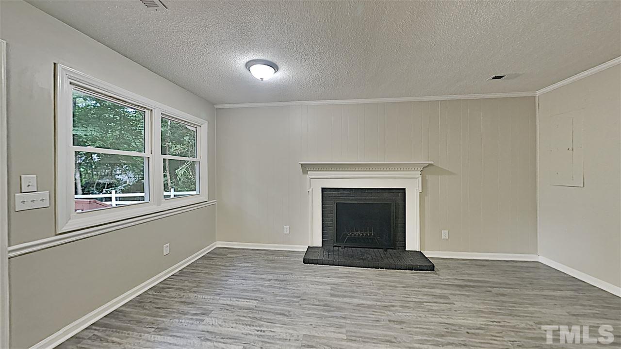 7209 Stuart Drive Raleigh, NC 27615 - Photo 5 of 13 a view of an empty room with wooden floor and a window