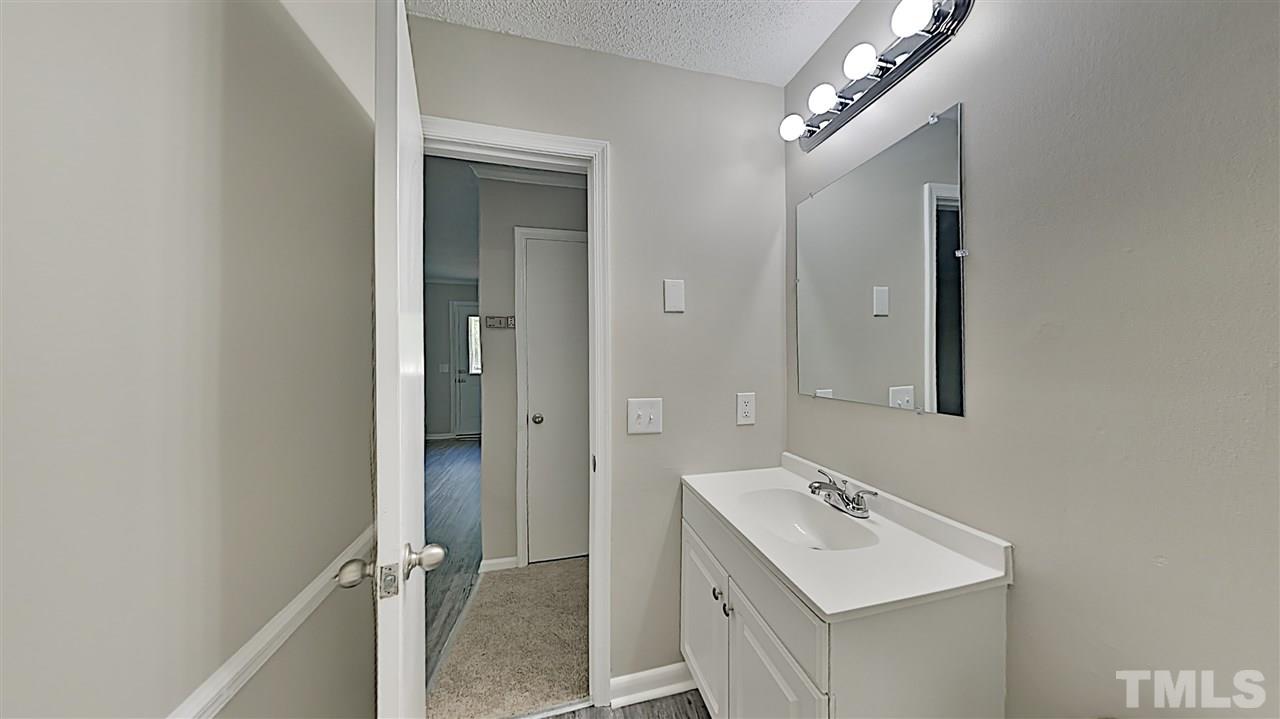 7209 Stuart Drive Raleigh, NC 27615 - Photo 10 of 13 a bathroom with a sink mirror and shower