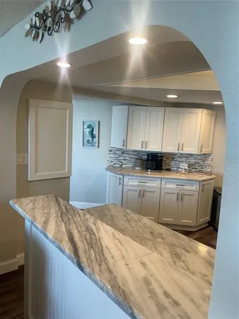 a kitchen with granite countertop a sink stainless steel appliances and cabinets
